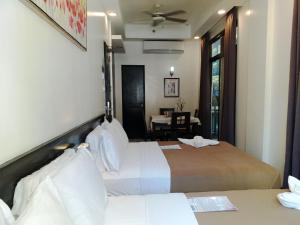 长滩岛新月广场酒店的酒店客房设有两张床和一张桌子。