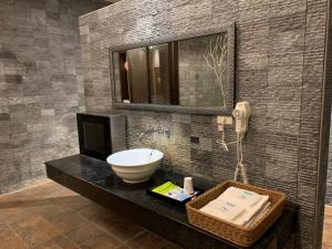 斗六市禾枫SPA汽车旅馆 - 斗六馆的一间带水槽和镜子的浴室以及一部电话