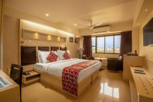孟买孟买国际机场东方紫菀酒店的配有一张床和一张书桌的酒店客房