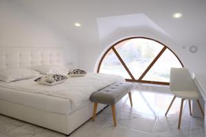 卢茨克Patio di Fiori的配有大窗户的客房内的白色床