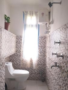 RongliAshraya Boutique Homestay的一间带卫生间和淋浴及窗户的浴室