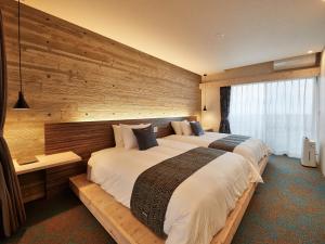读谷村Yomitan Condhotel ND的卧室设有两张床铺和木墙