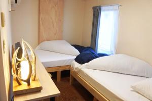 札幌沙伯洛基旅馆的带窗户的客房内的两张床