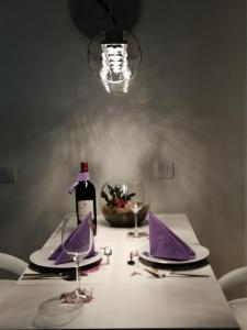 Nova PazovaApartman Lux的一张带紫色餐巾的桌子和一瓶葡萄酒