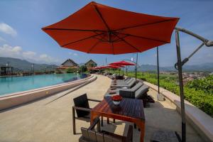 琅勃拉邦琅勃拉邦观景酒店的庭院配有桌椅和遮阳伞。