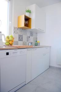 科佩尔Razgled/The View的厨房配有白色橱柜和一碗水果
