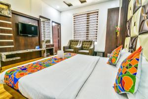 阿姆利则FabHotel Aman Residency Sharifpura的一间带大床和电视的卧室