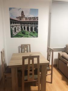 莱昂Apartamento céntrico en León的餐桌、椅子和墙上的绘画