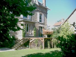 勒谢奈Les Chambres de LOUIS的一座大型石头房子,前面设有木甲板