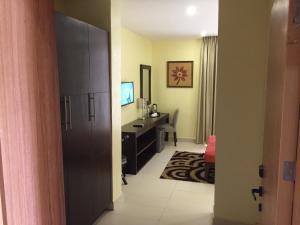 Ado EkitiAMOR Hotel Ekiti的酒店客房设有书桌和卧室。