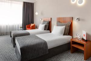 叶卡捷琳堡乌斯塔莫斯科夫斯卡亚格尔卡酒店的酒店客房设有两张床和一张桌子。