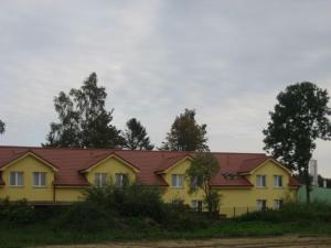 韦巴Ośrodek Wczasowo - Kolonijny Słoneczko的黄色的房屋,有红色的屋顶
