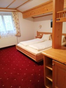 翁肯Berggasthof Hintergföll的一间卧室配有双层床和红地毯