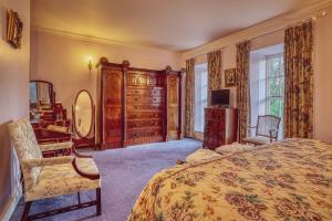 莱特肯尼城堡树林乡间酒店的一间卧室配有一张床、一张书桌和一个梳妆台