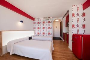 圣安东尼奥湾拉奇奇公寓的卧室配有白色的床和红色冰箱。