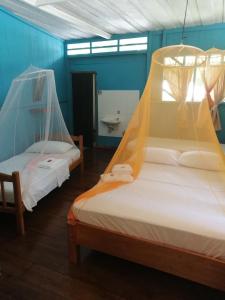 Puerto NariñoEware Refugio Amazonico的客房设有两张带蚊帐的床。