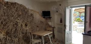 蓬扎L'Incanto di Cala Feola的石墙客房内的桌椅