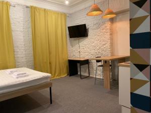 莫斯科Axel Apart Hotel Moscow的客房设有1张床、1张办公桌和1台电视。