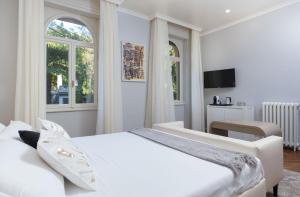 维罗纳Villa Natalia Luxury Rooms的白色卧室设有大床和窗户