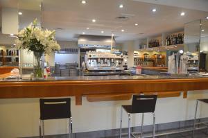 塔拉桑纳阿拉贡布鲁哈斯伊露酒店的餐厅设有酒吧,提供椅子和鲜花