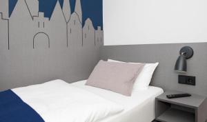HerrnburgStadtrandzimmer的卧室配有一张白色床,墙上挂有城市壁画