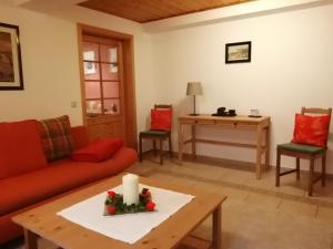 萨克森自由州诺伊斯塔滕Ferienwohnung Ulbrich的客厅配有红色的沙发和桌子