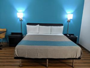 查塔努加Motel 6 Chattanooga - Airport的蓝色墙壁间的一张床位