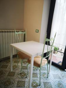 博尔塞纳B&B L ORTENSIA的窗户客房内的白色桌椅
