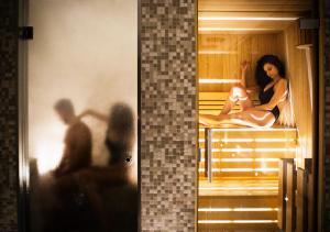索伦托欧陆酒店的坐在桑拿房的女人的两张照片