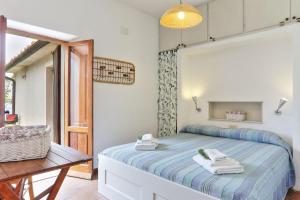 ZancaCasa La Capraia的一间卧室配有一张床、一张桌子和一个窗户。