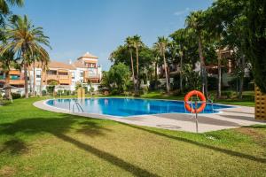 奇克拉纳－德拉弗龙特拉Apartamento Aldea del Coto的一座位于院子里的游泳池,四周环绕着红环