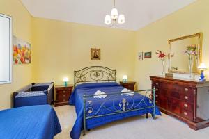 Santa Maria di LicodiaMalicodia的一间卧室配有蓝色的床和镜子