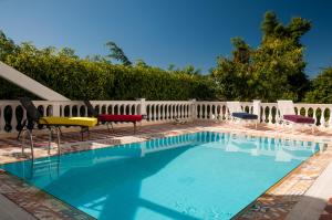 里约热内卢达科斯塔名誉酒店的一个带椅子和白色围栏的游泳池