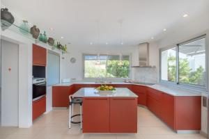 桑坦德利亚湾Villa Xipell 9的厨房配有红色橱柜和白色台面