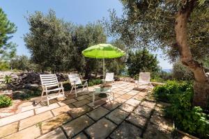 科尔萨诺Villa Azzurra的庭院里摆放着一组椅子和一把遮阳伞