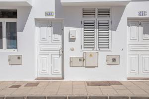 阿雷西费Casa Bonita Argana的白色的建筑,有白色的门和电子盒子
