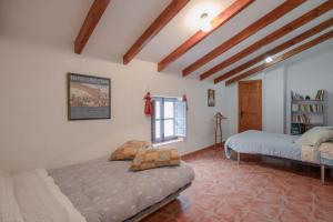 Canillas de AceitunoCasa Rural El Tesillo的一间卧室设有两张床和窗户。