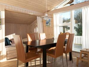 Ørby6 person holiday home in Knebel的一间用餐室,配有黑色的桌子和椅子