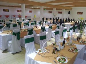 安托法加斯塔阿斯特瑞套房酒店的宴会的设置,包括白色桌子和绿色弓