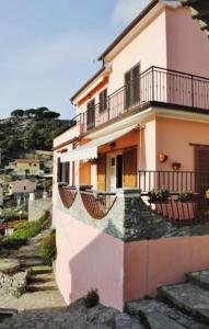 瑟克罗Appartamento Seccheto Mare的粉红色的房子,有楼梯通往