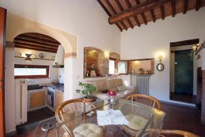 里奥内莱尔巴Villa La Padronale Isola d'elba-ortano的厨房以及带玻璃桌和椅子的客厅。