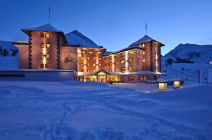 库哈台Hotel Alpenrose aktiv & sport的一座大建筑物,在晚上下雪