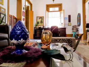 马瑙斯Casa Perpetua Hotel D Charm的客厅,玻璃桌上摆放着花瓶
