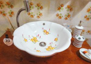 马瑙斯Casa Perpetua Hotel D Charm的浴室水槽,上面有鲜花,放在桌子上
