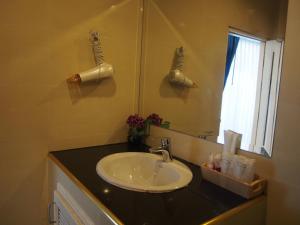 沙美岛农略客房酒店的一间带水槽和镜子的浴室