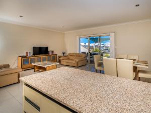朱里恩湾Seafront Unit 49的一间带厨房的客厅和一间带桌子的客厅
