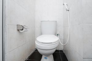 GununganjarSUPER OYO 91964 Menara Rungkut Surabaya的浴室内设有一个白色的卫生间,配有软管