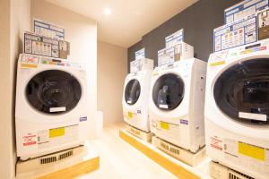 大阪唐草鼎盛酒店新大阪的洗衣房里摆放着三台洗衣机