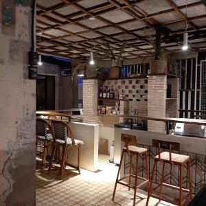 宿务The Flying Fish Hostel Cebu的厨房里设有带椅子和柜台的酒吧