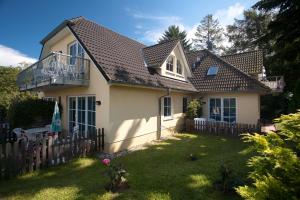 宾茨Haus Seeblick-Binz的白色的房子,有栅栏和院子